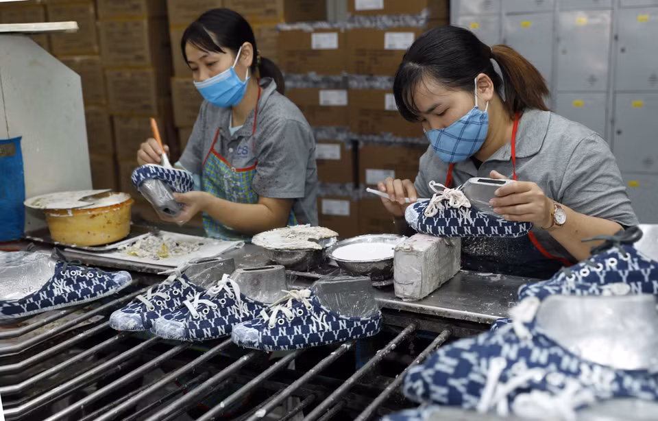 Production de chaussures destinées à l'exportation à la société à responsabilité limitée du tissage chimique d’Ha Tay. Photo : VNA