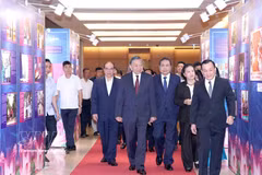 Le secrétaire général du Parti et président de la République, To Lam, accompagné d’autres dirigeants et d’anciens dirigeants du Parti et de l’État, visite une exposition intitulée « Des exemples simples mais nobles ». Photo: VNA