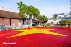 Dans le hameau de Giap Long, commune de Chuong Duong, l’atelier de Nguyên Van Trung s’affaire à achever un drapeau national géant de 600 m². Photo : Vietnam+