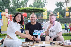 Des touristes étrangers dégustent le thé au lotus du Vietnam. Photo: VNA