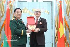 Le général Nguyen Trong Nghia, chef du Département général de la politique (gauche), offre un cadeau à Vasily Ivanovich Braga, président de l'Association des anciens experts militaires bélarusses ayant aidé le Vietnam. Photo: VNA