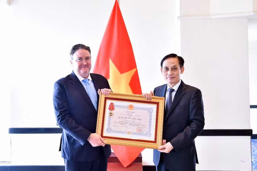 Le ministre des Affaires étrangères, Le Hoai Trung (droite), remet l’Ordre de l’Amitié à l’ambassadeur américain Marc Knapper. Photo: VNA