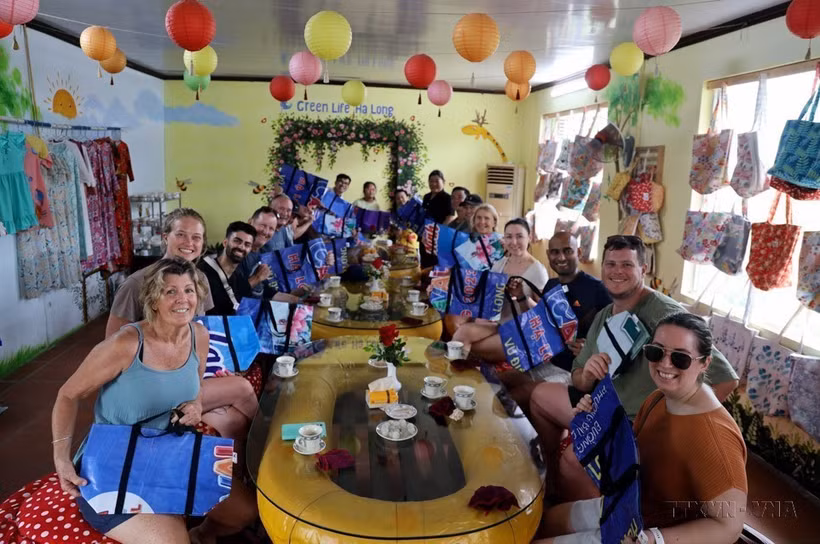 Les touristes étrangers apprécient les sacs fabriqués à partir des bâches en plastique de la coopérative Green Life Ha Long (Quang Ninh). Photo : VNA
