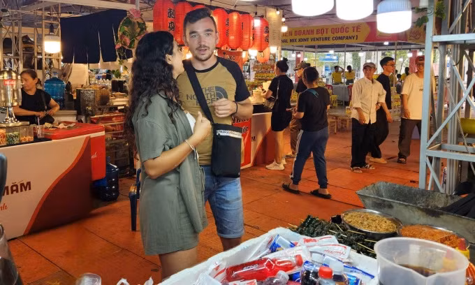 Maria et son petit ami cherchent des plats vietnamiens lors du festival le soir du 23 octobre. Photo: CPV