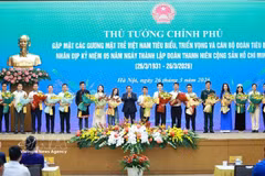 Le Premier ministre Pham Minh Chinh offre des fleurs de félicitations aux jeunes Vietnamiens exemplaires. Photo : VNA