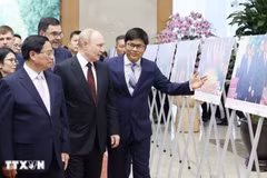 Le Premier ministre Pham Minh Chinh et le président russe, Vladimir Poutine, visitent une exposition de photos sur la coopération entre les deux pays. Photo: VNA