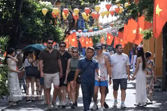 Des touristes étrangers visitent Hoi An. Photo : VNA