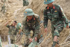 Des soldats s'efforcent de dégager les routes menant aux villages isolés par les inondations. Photo: VNA