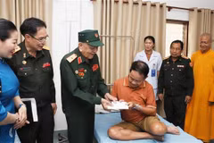 Le général Vo Van Chot, ancien commandant de la 324e division et ancien commandant adjoint de la Région militaire 4, remet le cadeau à un ancien combattant lao. Photo: VNA