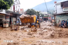 Des excavatrices aident à ramasser la boue, les branches d'arbres et les déchets emportés par les récentes inondations dans la commune de Song Ma, province de Son La. Photo : VNA