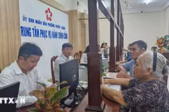 Des personnes viennent effectuer des démarches administratives lors du premier jour de mise en place du modèle d'administration locale à deux niveaux dans le quartier de Phuoc Thang, à Hô Chi Minh-Ville. Photo : VNA