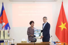 L'ambassadeur Nguyen Minh Vu remet des cadeaux du Têt à Ha Thi E, qui a contribué à la résistance contre l'armée américaine et a reçu un certificat de mérite du Premier ministre vietnamien en 2009. Photo : VNA