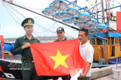 Remise de drapeaux nationaux à des pêcheurs. Photo : VNA