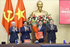 Le président de l’Assemblée nationale, Tran Thanh Man, a remis la décision, et le Premier ministre Pham Minh Chinh a offert des fleurs pour féliciter Nguyen Hong Dien. Photo: VNA